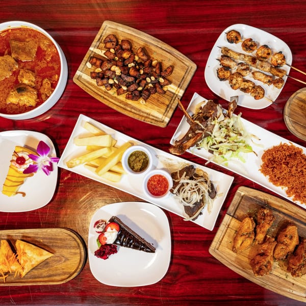 Overhead view of various African dishes, including stews, skewers, fried plantains, and desserts.
