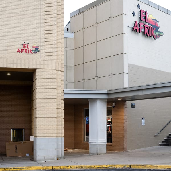 Exterior view of El Afrik Cuisine and Bar, with its logo on a light brick building.